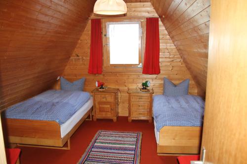 1 dormitorio en el ático con 2 camas y ventana en Haus Gimpel Flumserberg, en Flumserberg