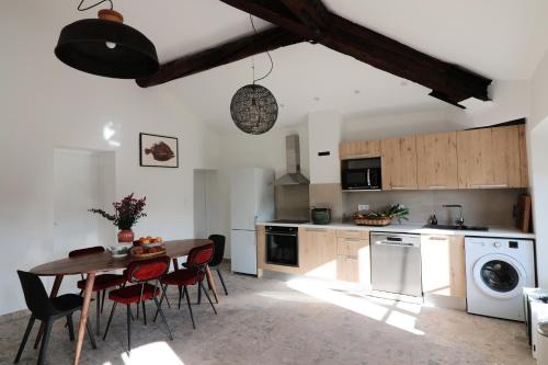 a kitchen with a table and chairs and a kitchen with a washer at Appartements à la ferme in La Ciotat