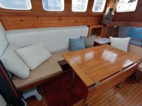 a small table and a bench in a boat at Sailing Yacht in Fiskardo