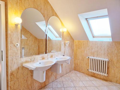 a bathroom with two sinks and a mirror at ROMANTIK HOTEL ELEONORA in Tábor
