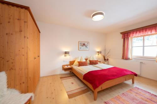 ein Schlafzimmer mit einem großen Bett und einem Fenster in der Unterkunft Molteraugut in Mühlbach am Hochkönig