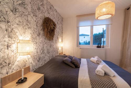 ein Schlafzimmer mit einem Bett und einer Wand in der Unterkunft DIFY Ethnic Chic - Parilly in Vénissieux