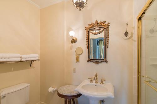 a white bathroom with a sink and a mirror at The Burn Bed and Breakfast in Natchez