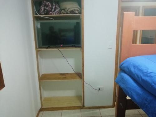 um quarto com uma televisão e uma cama num quarto em Mumus em La Serena