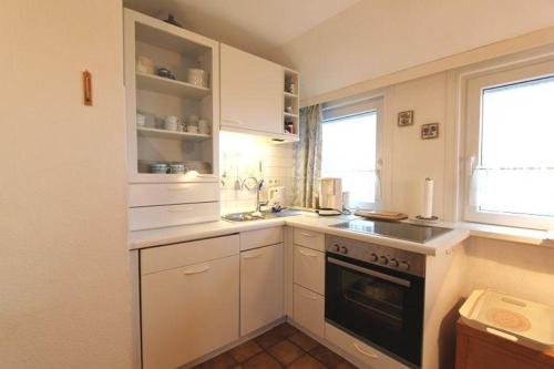 a kitchen with a stove and a sink and a window at Seewarte in Hörnum