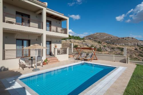 a villa with a swimming pool and a house at Porto Plaza Hotel in Agios Ioannis Kaspaka