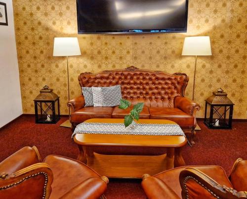 a living room with a couch and leather chairs at ROMANTIK HOTEL ELEONORA in Tábor