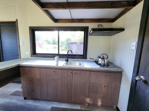 a kitchen with a sink and a window at Cabañas Alto Bosque in Pucón