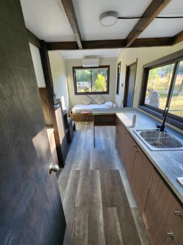 una cocina con fregadero y una cama en una habitación en Cabañas Alto Bosque, en Pucón