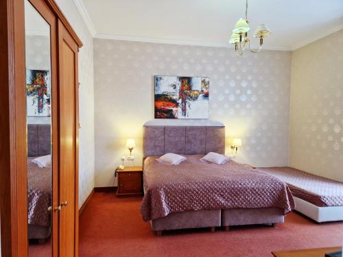 a bedroom with two beds and a mirror at ROMANTIK HOTEL ELEONORA in Tábor