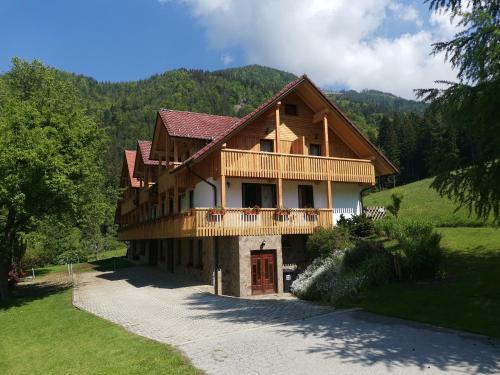 a large wooden house with a balcony on a mountain at Turistična Kmetija Zgornji Zavratnik in Luče