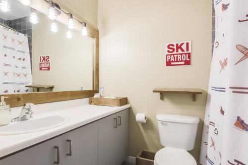 ein Badezimmer mit Waschbecken, Toilette und Spiegel in der Unterkunft Le Cozy-Condo à louer à Stoneham (CITQ 239956) in Stoneham