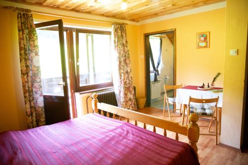 a bedroom with a bed and a dining room with a table at Turistična Kmetija Zgornji Zavratnik in Luče