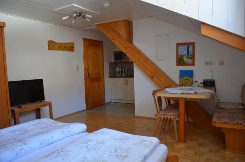 ヘルマゴルにあるRauterhofのベッド2台、テーブル、階段が備わる客室です。