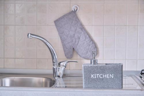 a kitchen sink with a k kitchen sponge on it at [Seveso-Stazione] Design, Wifi & Garage Privato in Seveso