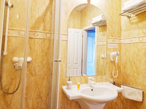 a bathroom with a sink and a shower with a mirror at ROMANTIK HOTEL ELEONORA in Tábor