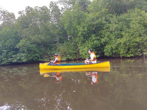 two people in a yellow canoe on a river at Green Hill Paradise Villa in Unawatuna