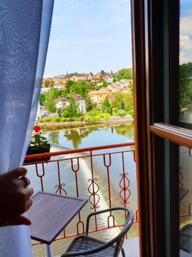 a window with a table and a view of a lake at ROMANTIK HOTEL ELEONORA in Tábor