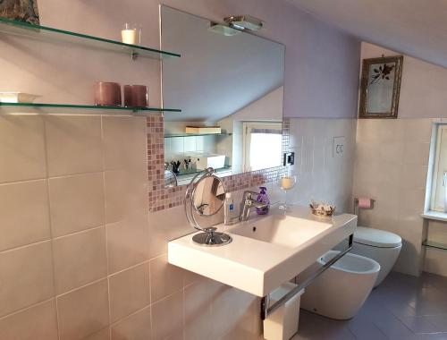 a bathroom with a sink and a toilet and a mirror at La Stanza dei Sogni in Saluzzo