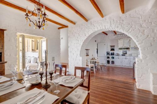 a dining room with a table and a stone wall at Villa Danae by the sea in Pounda