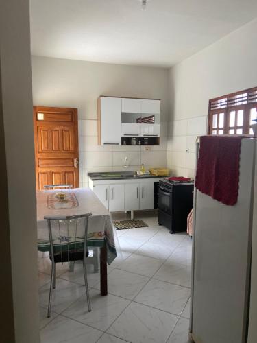 eine Küche mit einem Tisch und einem Kühlschrank in der Unterkunft Casa agradável no centro in Bananeiras