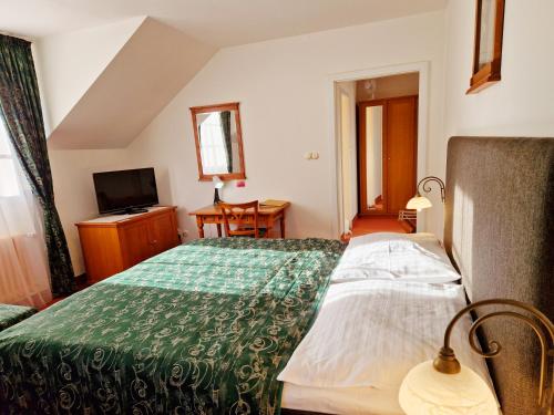 a hotel room with a bed and a television at ROMANTIK HOTEL ELEONORA in Tábor