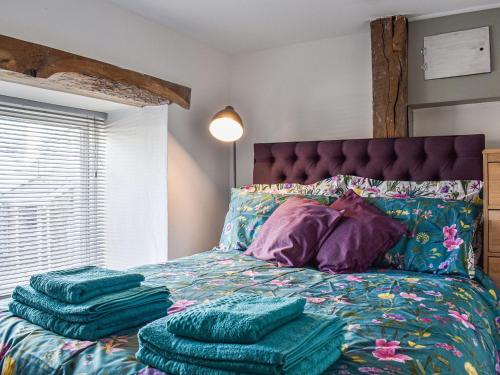 a bedroom with a bed with green towels on it at Old Skittle Alley in High Bickington