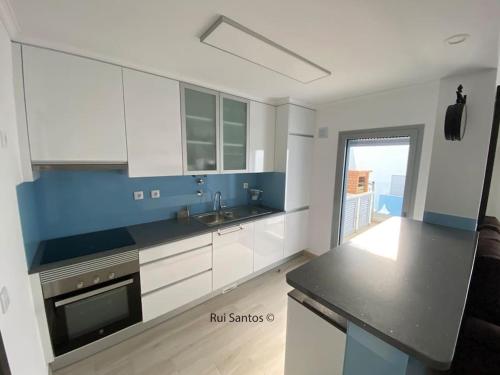 a kitchen with white cabinets and a black counter top at Manta Villa 2 in Manta Rota