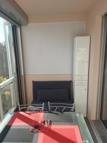 ein kleines Schlafzimmer mit einem Bett und einem Kühlschrank in der Unterkunft Studio Les Jardins de la Mer in Bandol