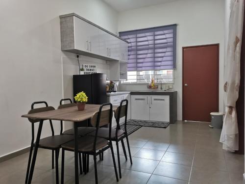 a kitchen with a table and chairs and a refrigerator at De'Sara Damai Homestay, Kuantan in Kuantan