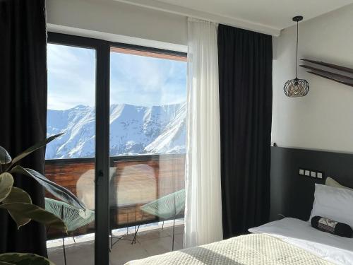 a bedroom with a window with a view of a mountain at Luxury hotel room with amazing views in Gudauri
