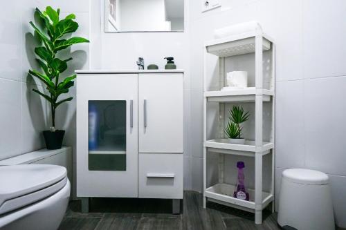 a white bathroom with a toilet and a sink at Bioparco Apartment in Valencia