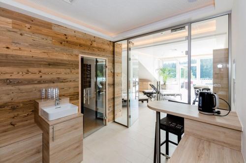 uma casa de banho com uma parede em madeira e um lavatório. em R&R Residenzen Ferienwohnungen em Mitterbach