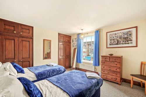 a bedroom with two beds and a dresser and a window at Lovely 2 bedroom duplex apartment, Maidstone sleeps 5 in Maidstone