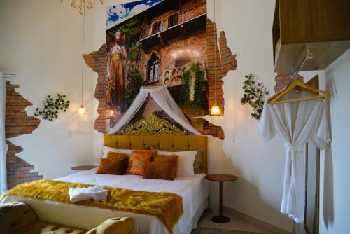 a bedroom with a bed with a painting on the wall at Pousada Boutique Mirante d'Italia in Pirenópolis