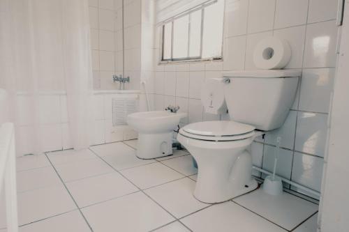 a white bathroom with a toilet and a sink at Mondrian Santiago in Santiago