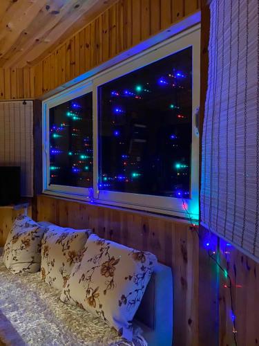 a bedroom with a window with christmas lights in it at Ethno village & resort Ćorić in Mojkovac