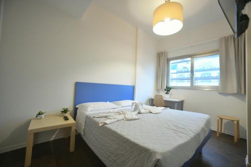 a bedroom with a white bed with a blue headboard at Garden Blue in Florence