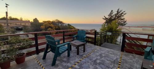 2 sillas y una mesa en un balcón con vistas al océano en Yemanya Hostal, en Concón