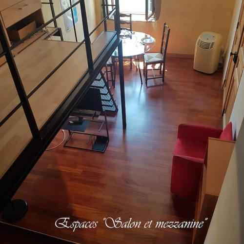 un salon avec une table et un canapé rouge dans l'établissement Semi-duplex Ancien Hôtel Particulier, à Bourg-en-Bresse