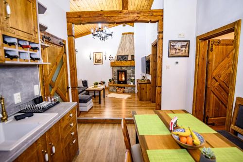 a kitchen and dining room with a table and a fireplace at Къща за гости Плевнята in Bansko