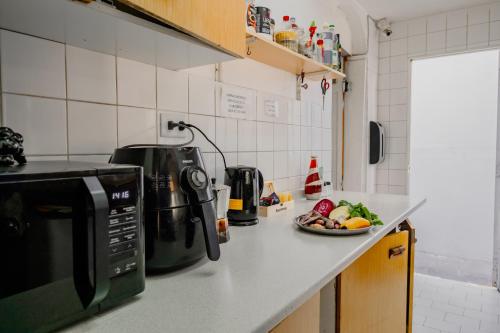 a kitchen counter with a microwave and a plate of food at Mondrian Santiago in Santiago