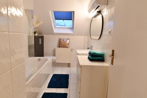 a white bathroom with a tub sink and a mirror at Heimat Floral Ferienhaus in Wadgassen