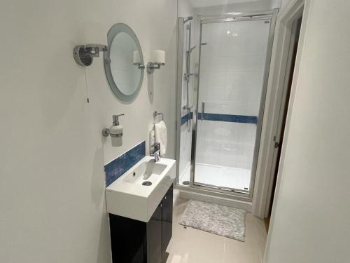 a white bathroom with a sink and a shower at Charming BRIGHTONMEWS cottage parking 1min to sea&shops in Brighton & Hove