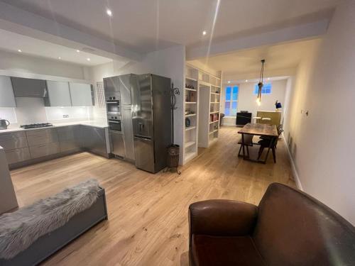 a large living room with a couch and a kitchen at Charming BRIGHTONMEWS cottage parking 1min to sea&shops in Brighton & Hove