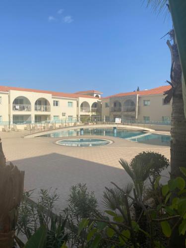 a swimming pool in a courtyard of a building at Elegant 1 Bedroom Apartment - Great Kings Resort Protaras, Kapparis in Paralimni
