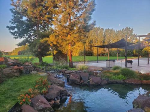 a garden with a pond with rocks and trees at Lazy Bear Ranch in Weiser