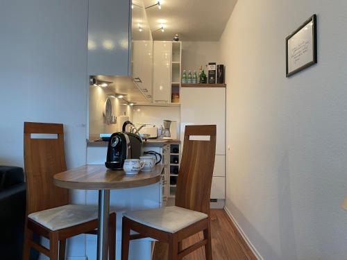 una piccola cucina con un piccolo tavolo e sedie di Apartment Nordseeblick a Sankt Peter-Ording