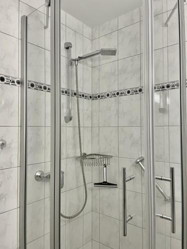 a shower with a glass door in a bathroom at Apartment Nordseeblick in Böhl