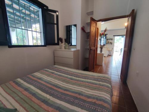 - une chambre avec un lit dans une pièce dotée de fenêtres dans l'établissement Casa Portal, à El Palmar